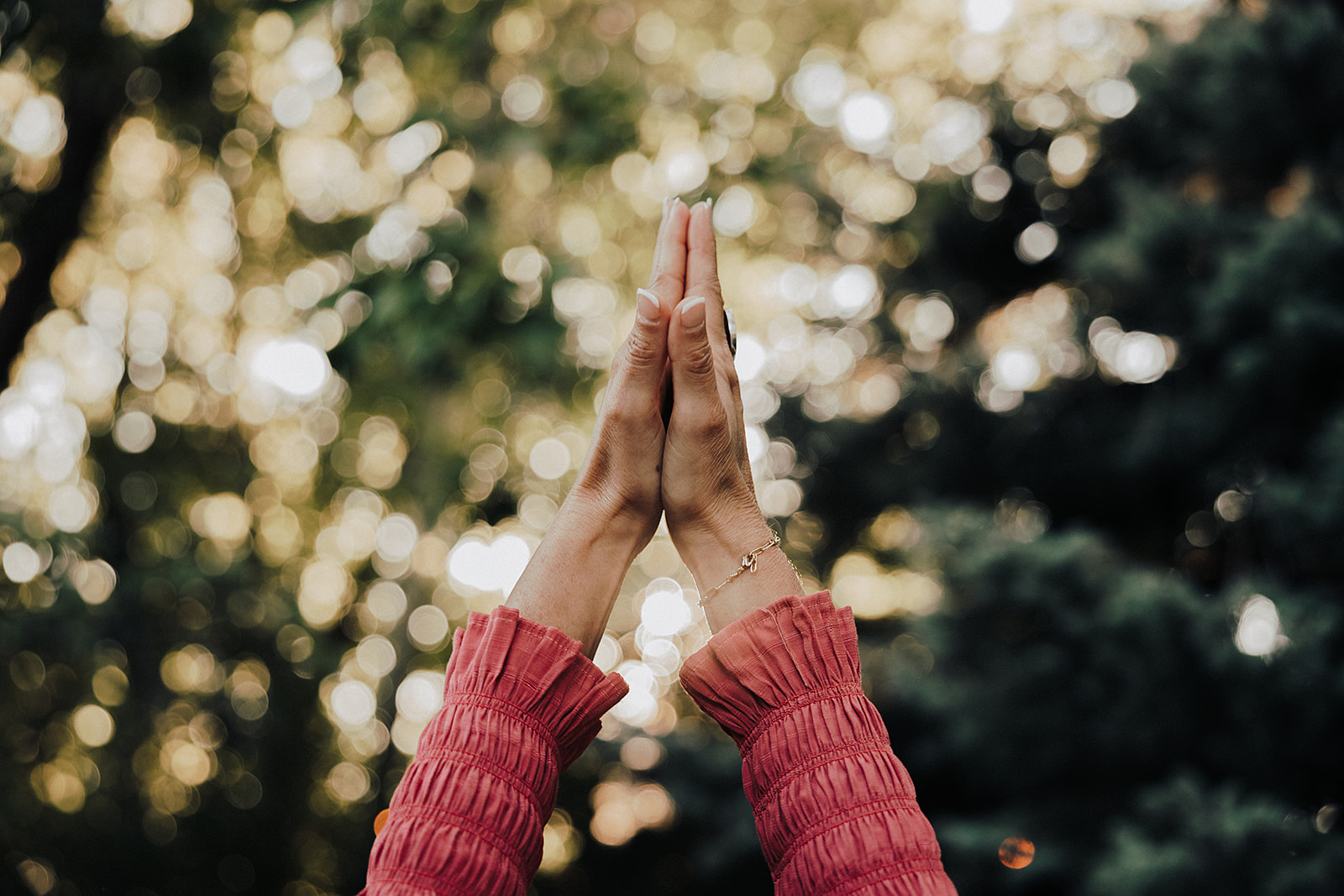 Patty with her hands in prayer reaching upwards